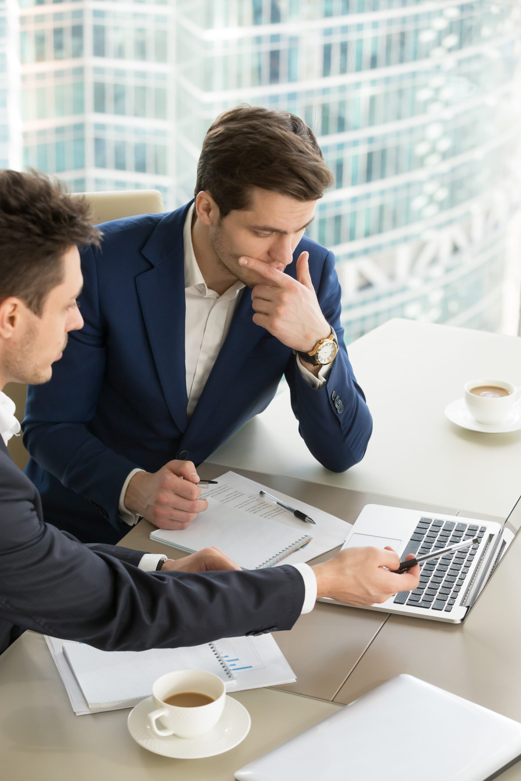Entrepreneurs discussing work results on meeting Business partners using laptop while working together on important corporate project in office. Businessman attentively listening to adviser Investment specialist making presentation of promising deal